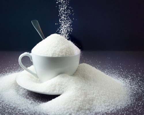 sugar-spoon-is-poured-into-cup-dark-background-concept-risk-health-too-much-sugar_191543-1437